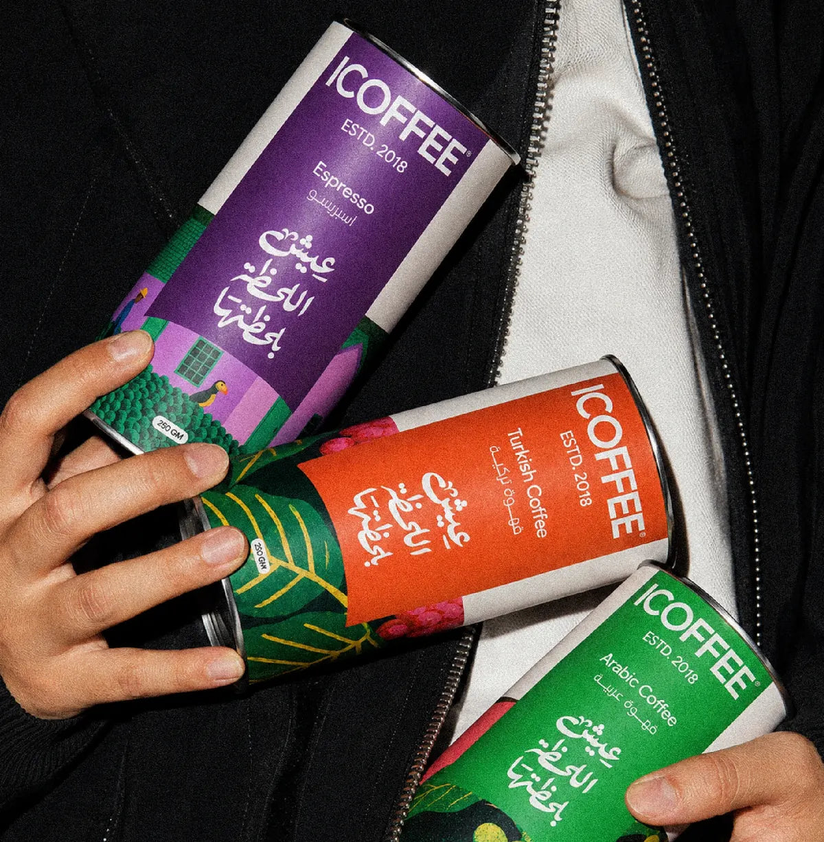 Hands holding ICOFFEE Espresso, Turkish and Arabic coffee cans